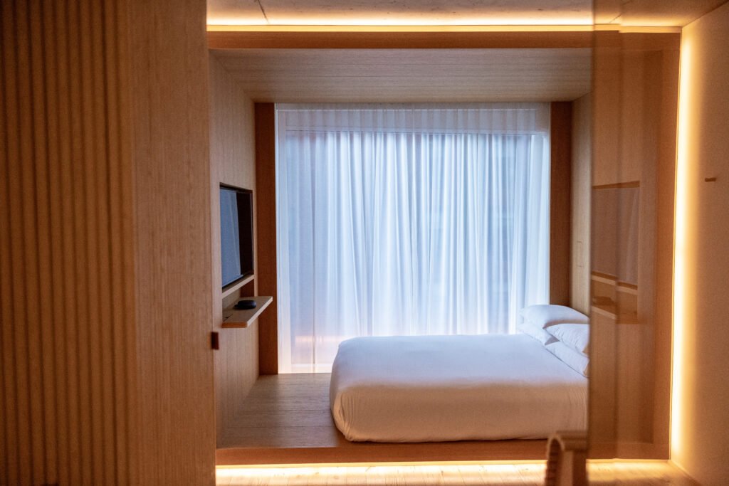 Bright bedroom interior showing bedroom furniture settings with a neatly placed bed, bedside tables, and coordinated decor arranged for a functional layout.