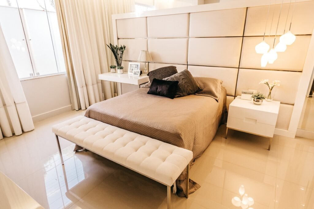 High-angle shot of a beige bedroom showing bedroom furniture settings with a bed, side tables, and coordinated storage arranged in a neutral layout.