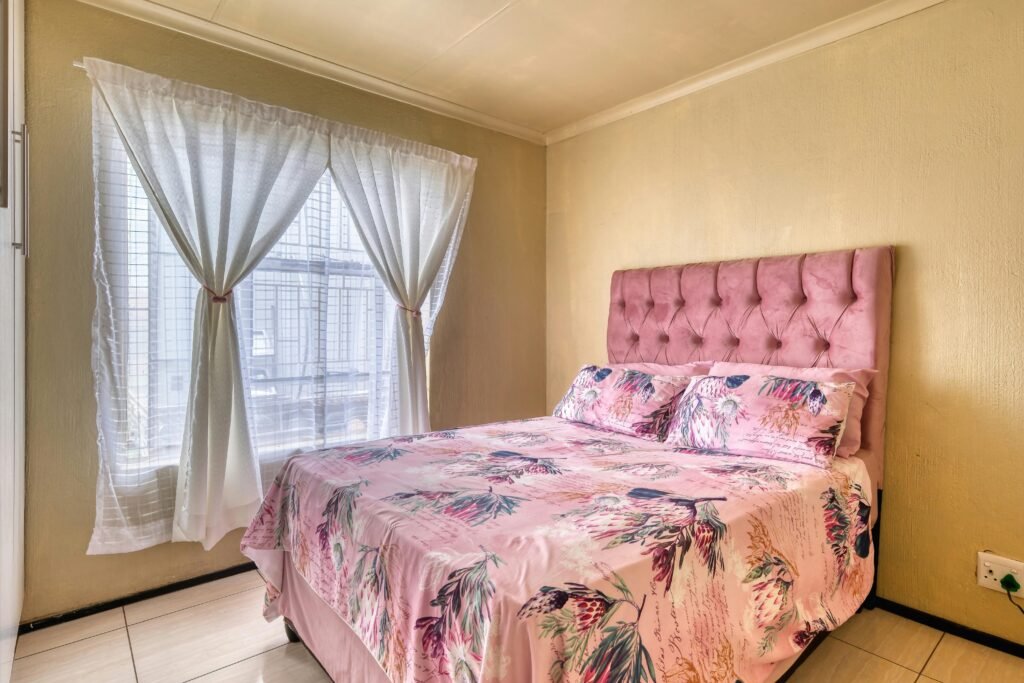 Bedroom decor ideas with a modern minimalist bed, soft neutral bedding, and warm ambient lighting for a cozy feel