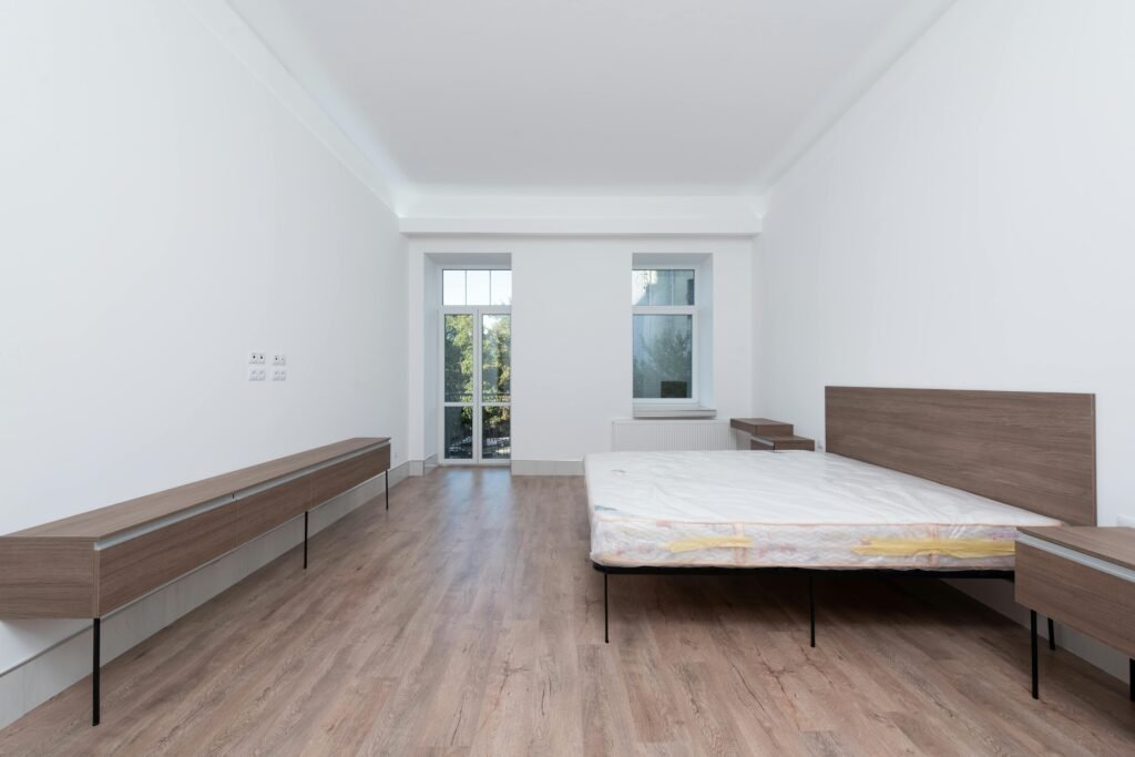 "Modern bedroom interior with upholstered bed, bedside tables, and decorative lighting accents