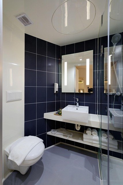 Hotel-style bathroom remodel with modern vanity, glass-enclosed shower, and elegant tile finishes