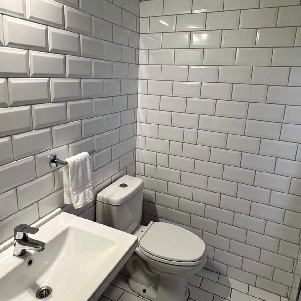 Bathroom with white subway style tiles arranged in a classic brick pattern on the walls.