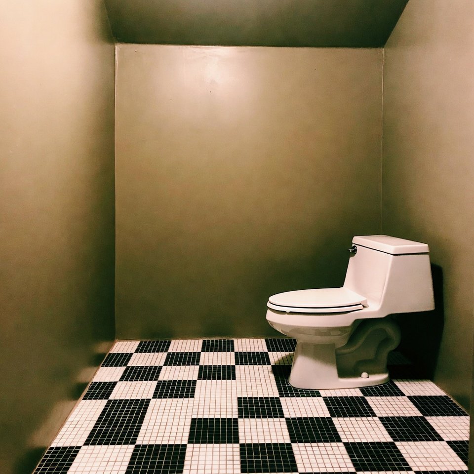 Bathroom with black and white checkerboard tile floor creating a bold geometric pattern.
