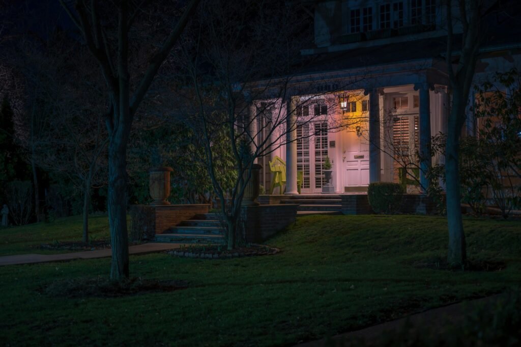Modern front yard with outdoor lighting, featuring illuminated pathways, garden lights, and a well-lit entrance