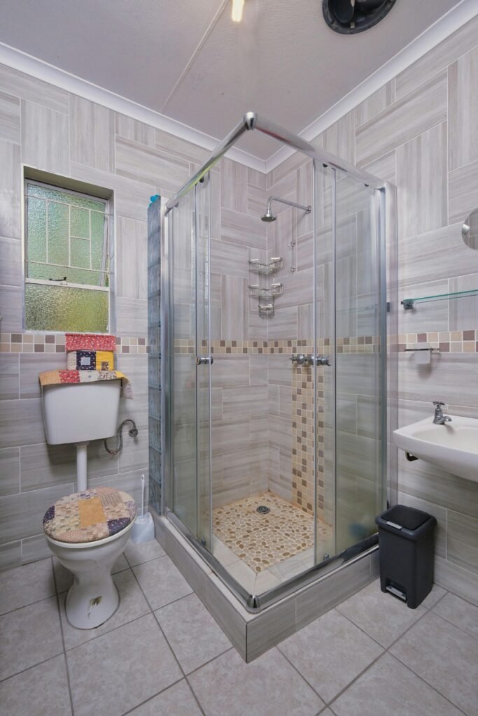 Luxury bathroom with a frameless glass door for shower, marble walls, and modern fixtures
