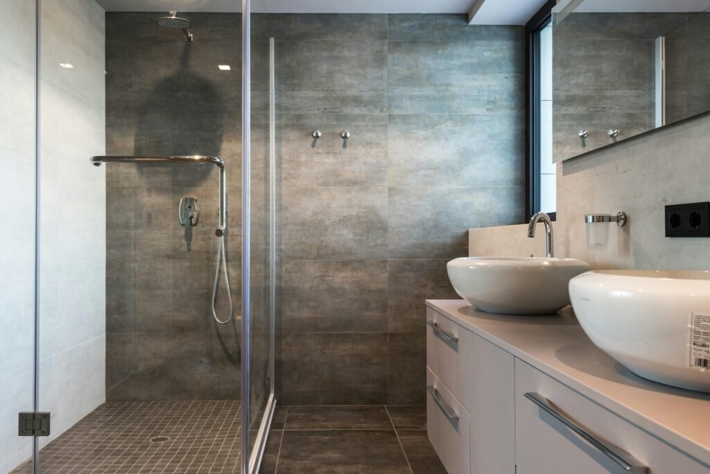 Modern bathroom with glass door for shower featuring frameless design and clean neutral tiles