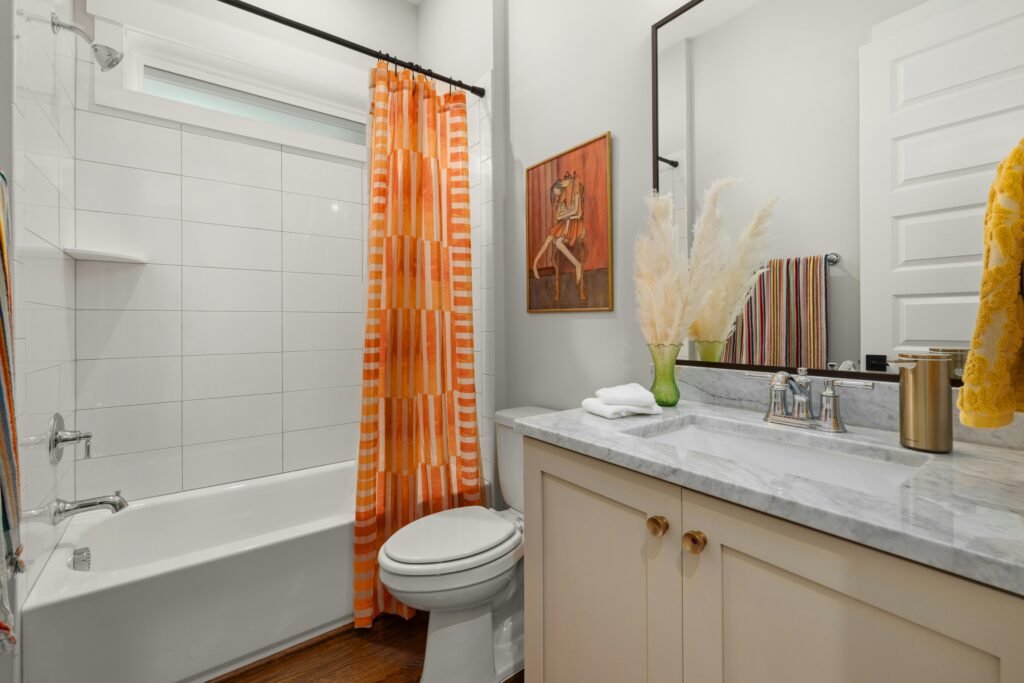 Modern bathroom with neutral shower curtain, sleek vanity, and soft ambient lighting