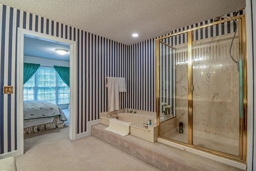 Spacious modern bathroom with a frameless glass door for shower and neutral tile walls