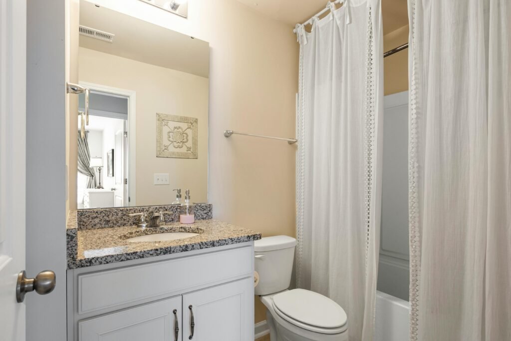 Contemporary bathroom with striped shower curtain, modern sink, and clean tile walls
