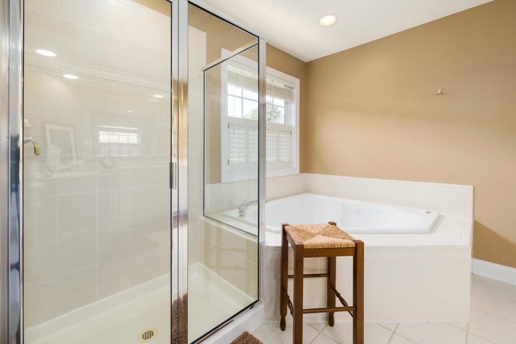 Modern bathroom with a frameless glass door for shower, light tiles, and a sleek minimal layout