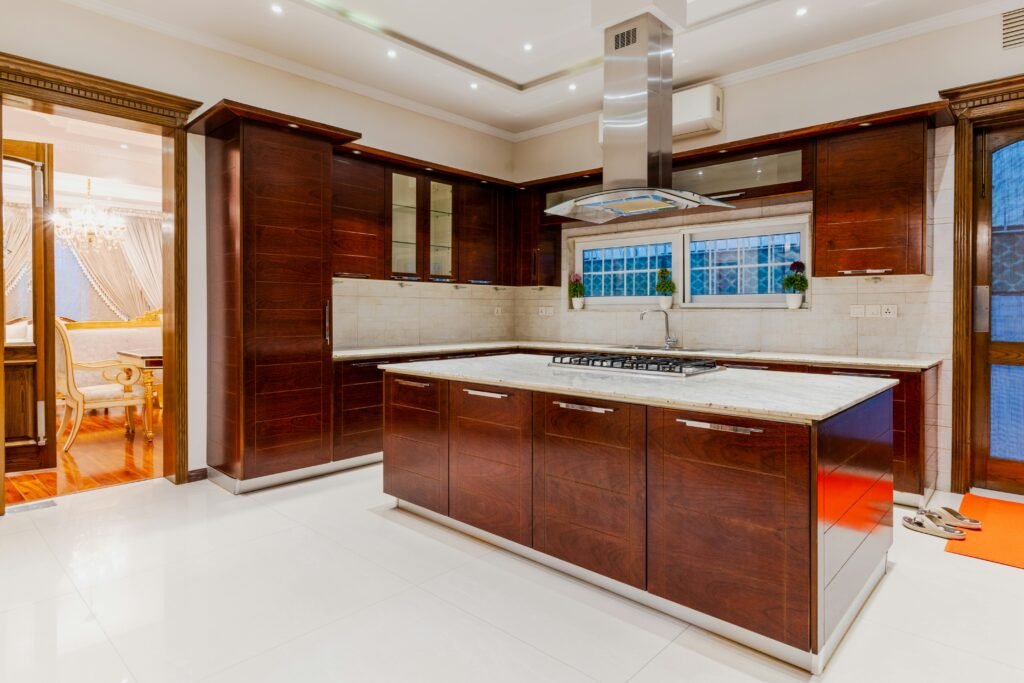Stylish kitchen with a modern kitchen range exhaust hood above the cooktop, sleek cabinets, and soft lighting.