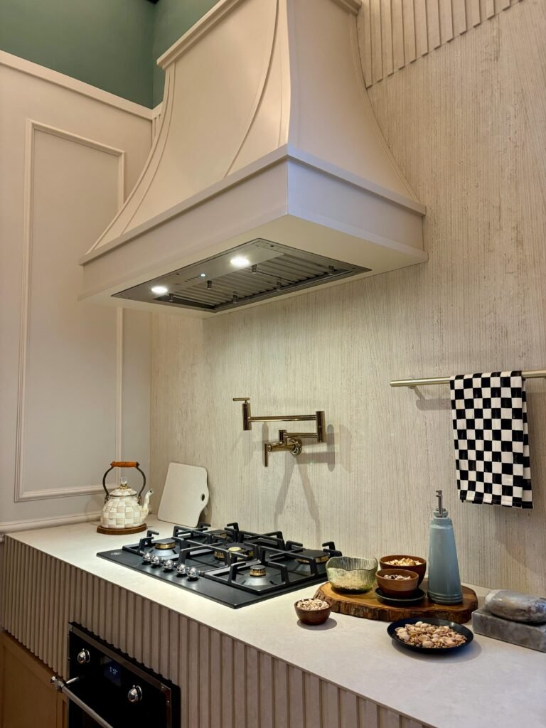 Contemporary kitchen with a kitchen range exhaust hood above the stove, modern cabinets, and warm lighting.
