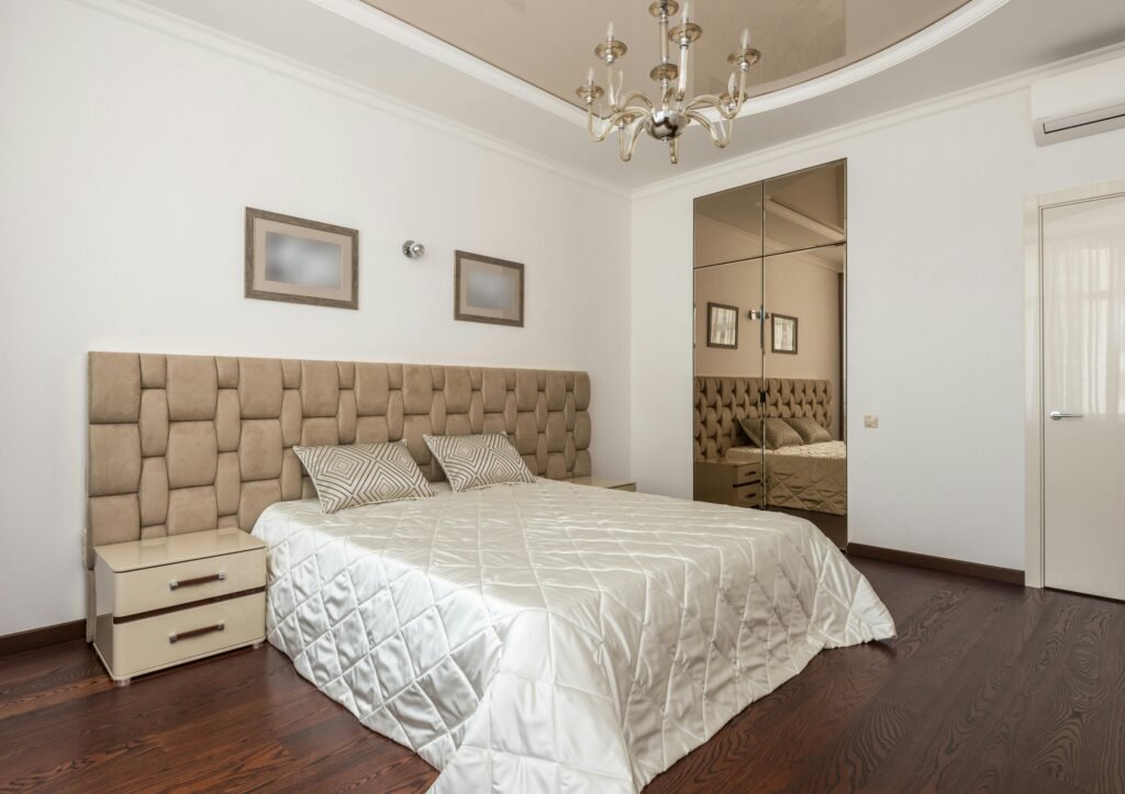 Affordable house in the USA featuring bedroom decorating ideas with large mirrors that reflect natural light and make the room appear more spacious.