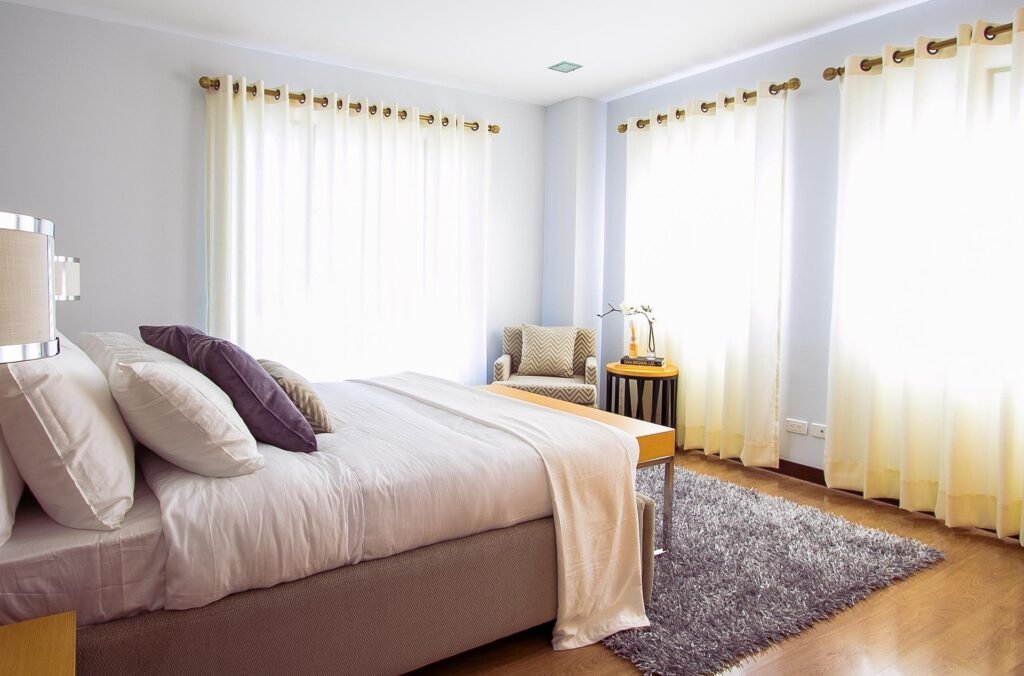Master bedroom design ideas featuring high ceiling curtains, a tall cupboard, neutral decor, and a spacious luxury bedroom layout.