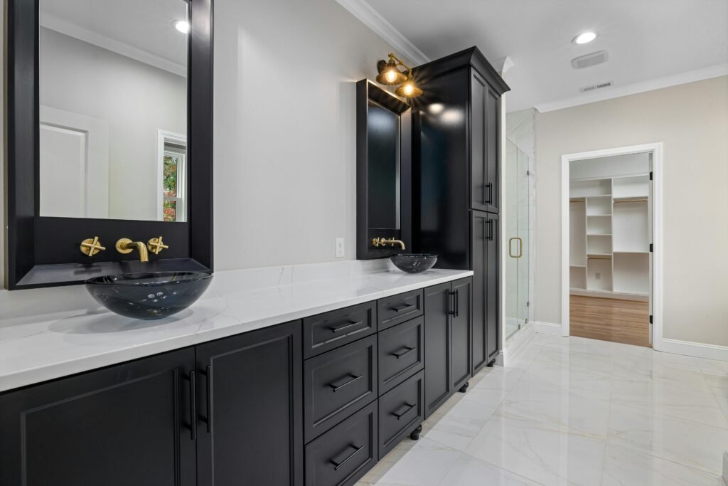 Modern bathroom featuring matte black fixtures, including faucets, shower hardware, and accessories, creating striking contrast.