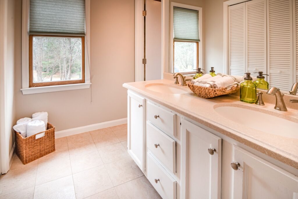Modern bathroom with large hidden storage cabinets, concealed shelving, and a clean, organized design.