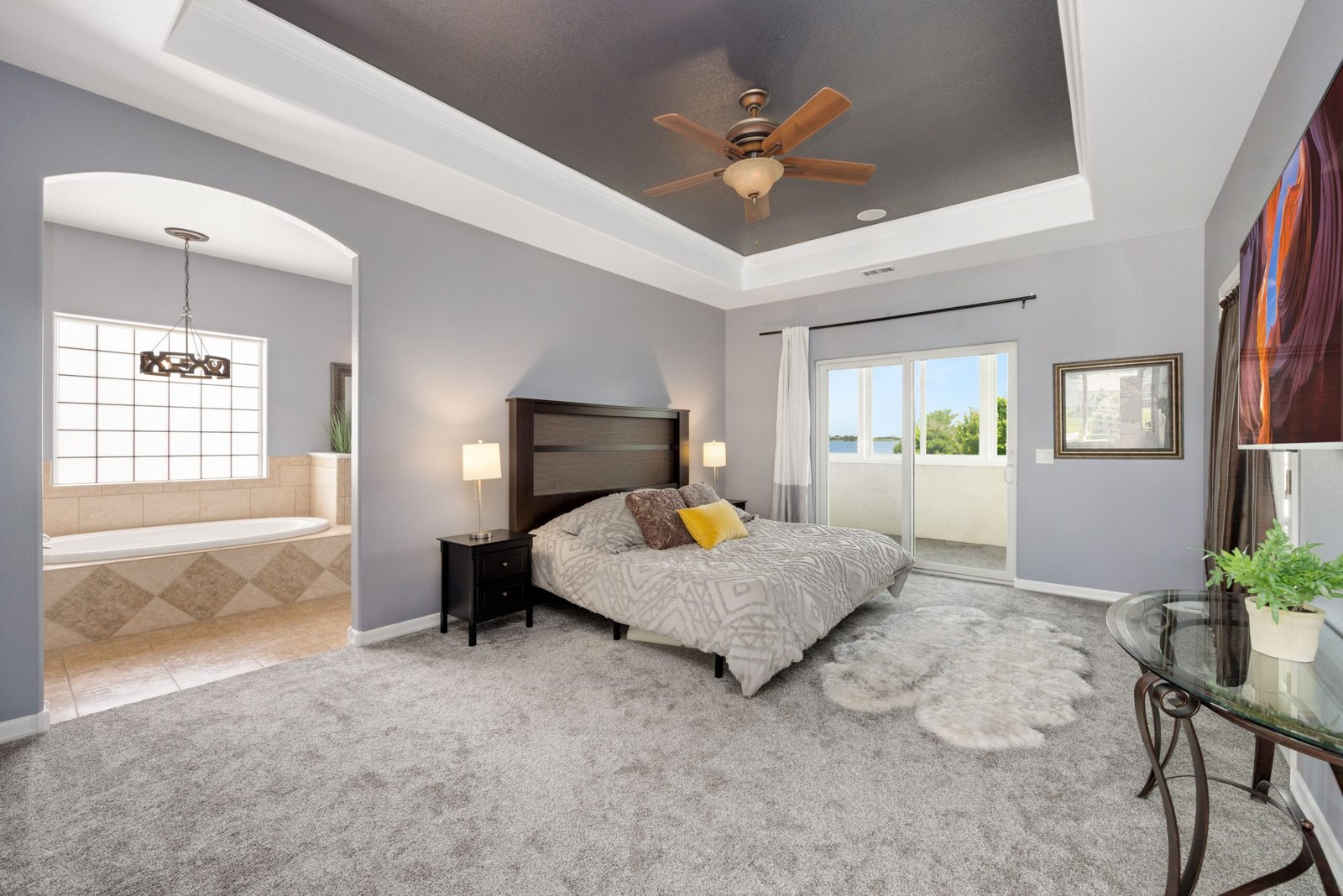 Modern master bedroom featuring a king-size bed, elegant lighting, neutral color palette, stylish furniture, and contemporary décor.
