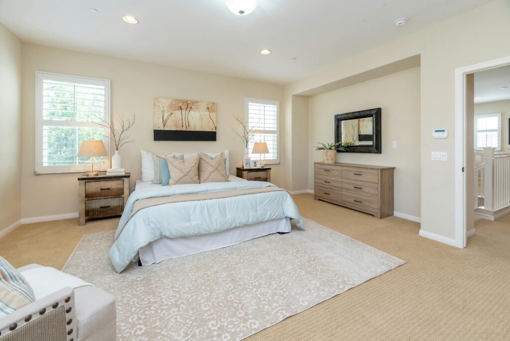 Master bedroom design ideas featuring a large area rug, comfortable bed, elegant decor, and a warm, inviting bedroom interior.