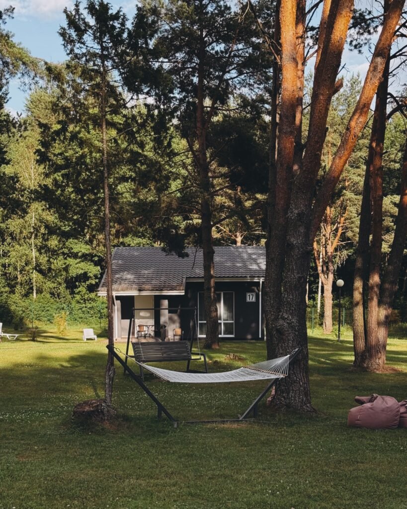 Low maintenance backyard ideas without grass featuring a cozy hammock relaxation zone, gravel landscaping, decorative plants, and a peaceful outdoor retreat.