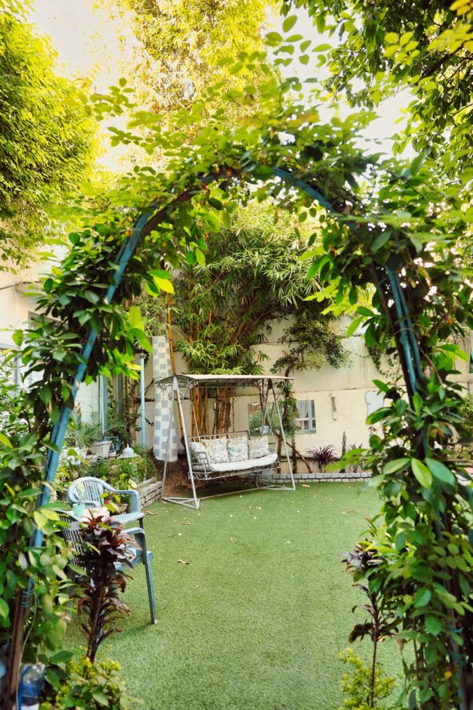 Low-maintenance backyard without grass featuring a container garden patio with colorful potted plants, decorative planters, paved flooring, and comfortable outdoor seating.