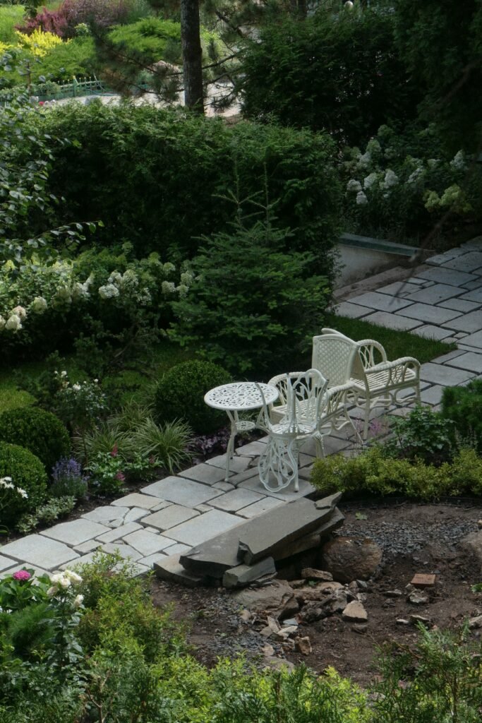 Low maintenance backyards without grass featuring a spacious stone patio, modern outdoor seating, decorative gravel, and drought-tolerant landscaping.