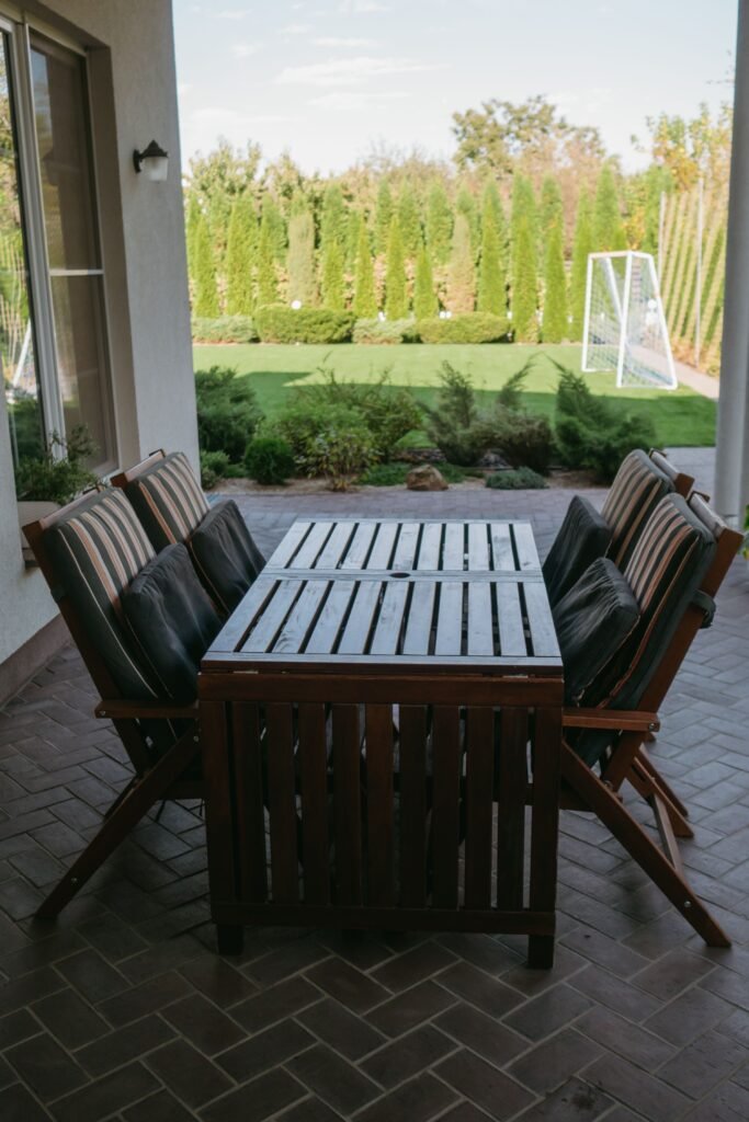 Low maintenance backyards without grass featuring a multi-zone outdoor layout with a dining area, lounge space, gravel pathways, and drought-tolerant landscaping.