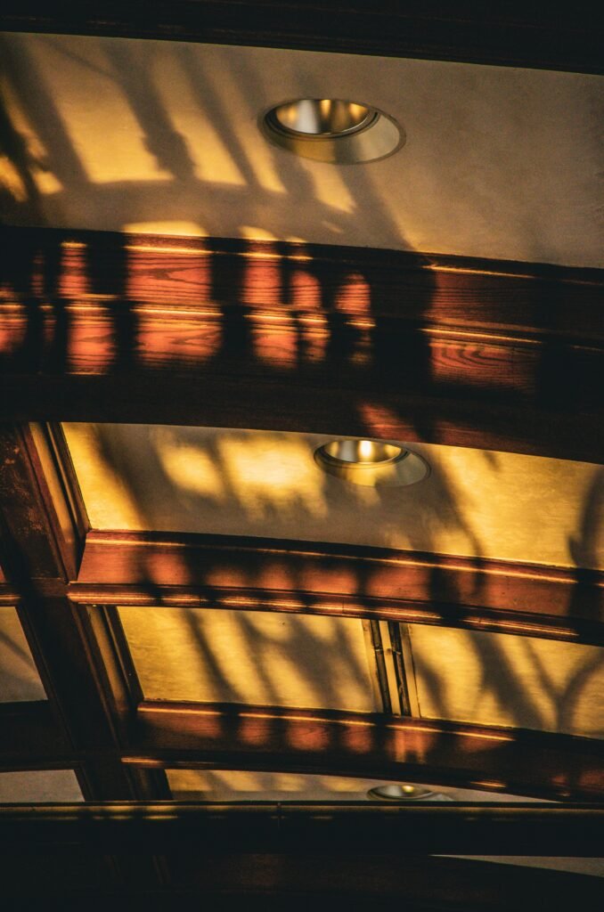 Coffered ceiling with decorative beams featuring detailed trim, recessed panels, and elegant craftsmanship that adds depth and character.
